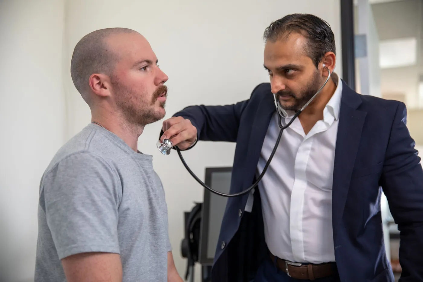 Dr. Bhavesh Patel, D.O., examining a patient with a stethoscope