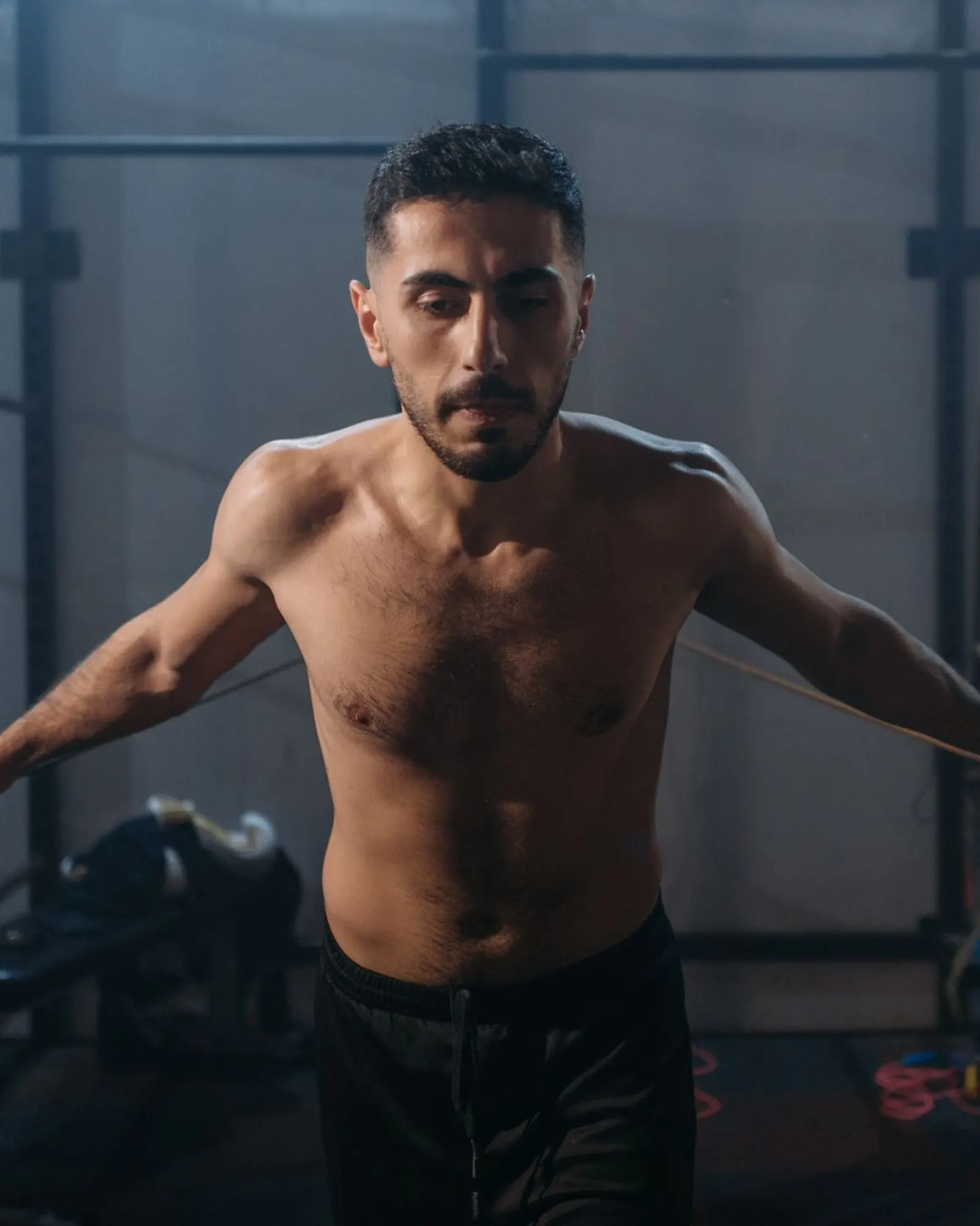 A man mid-workout in a gym, arms extended