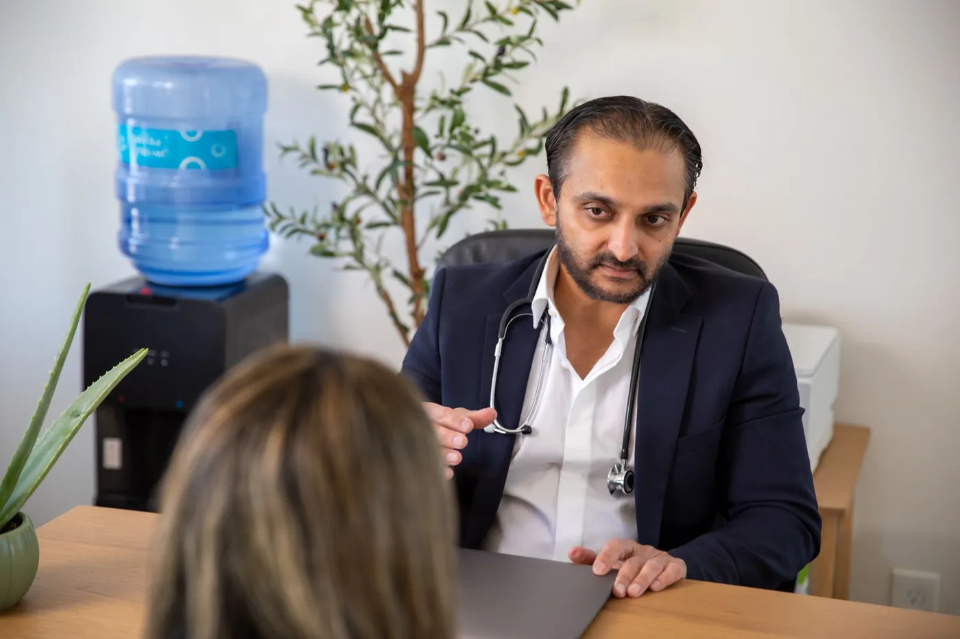 Dr. Bhavesh Patel in conversation with a patient across the consultation desk