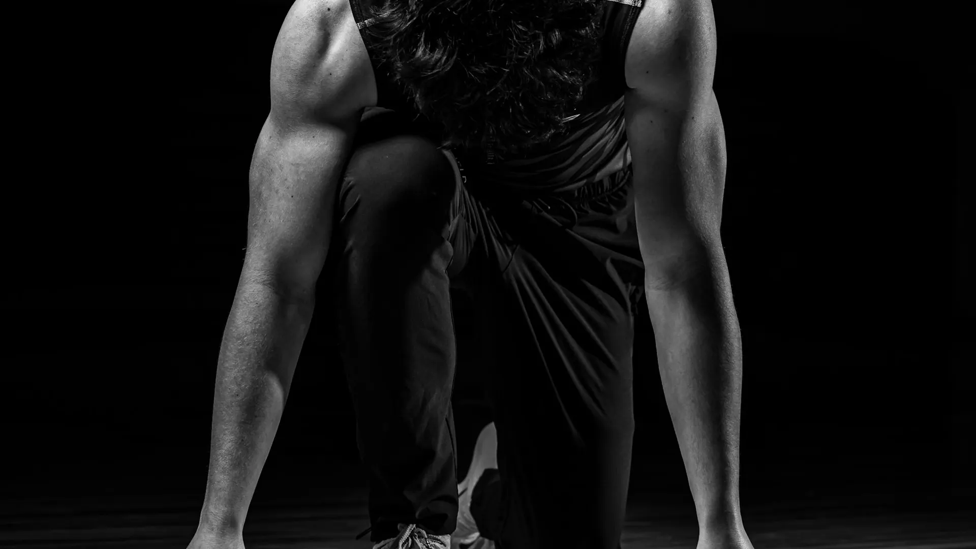 Muscular arms of a sprinter braced in a starting crouch