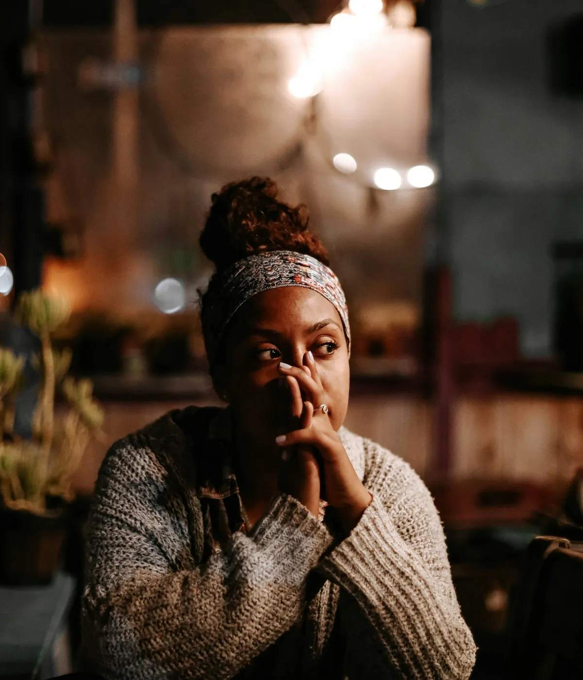 A woman resting her chin on her hands in thought