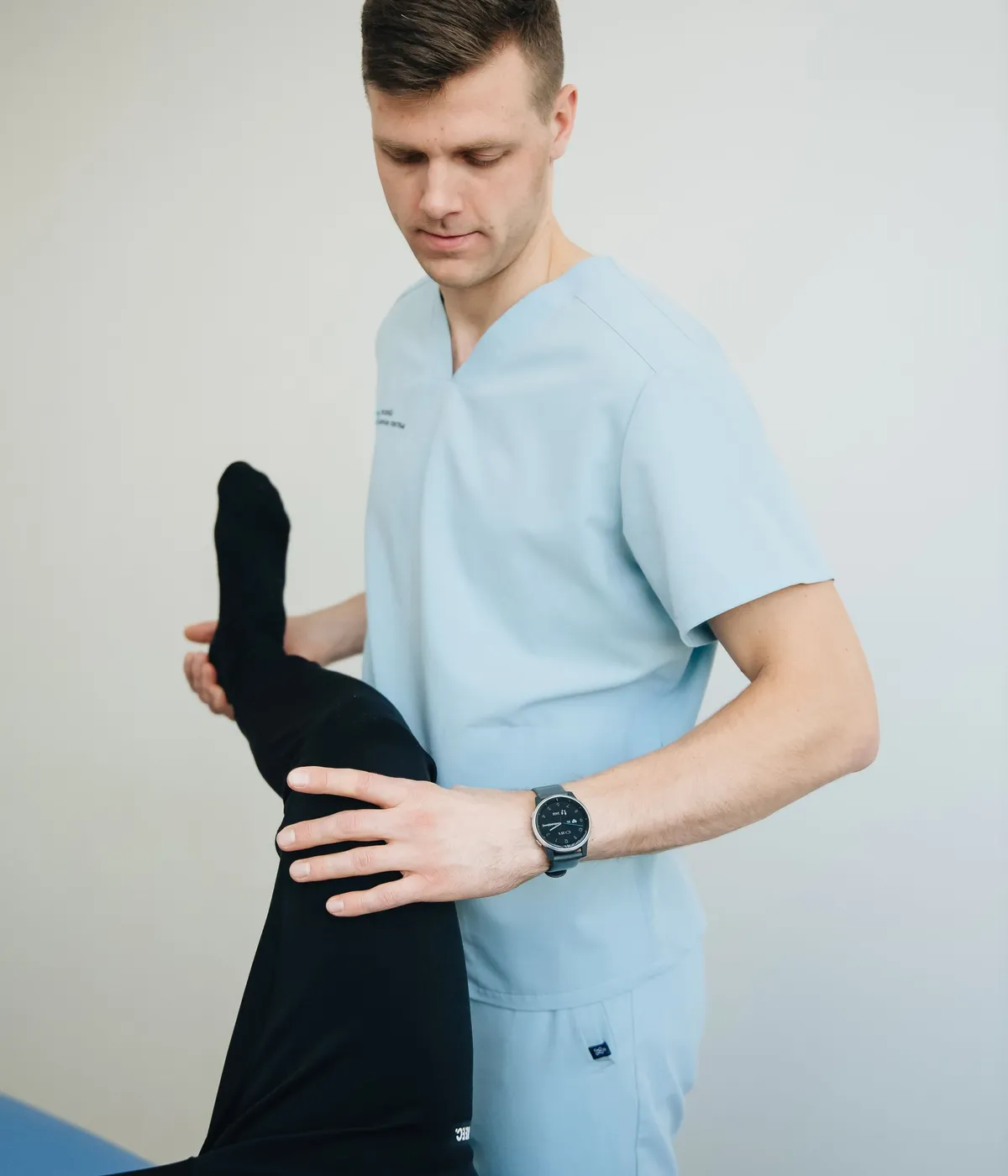 A physiotherapist guiding a patient's leg through a stretch